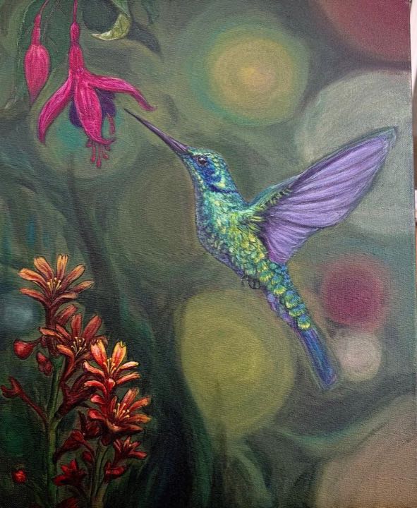Iridescent hummingbird hovering by a pink fuchsia flower